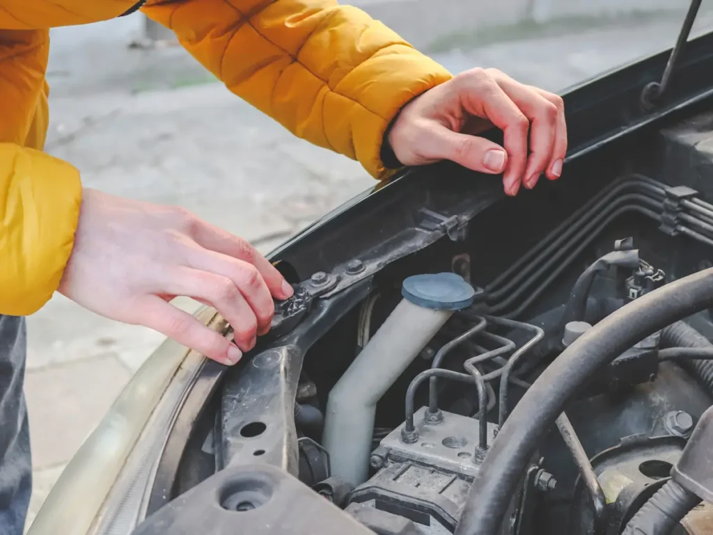 Une personne qui regarde sous le capot d'une voiture
