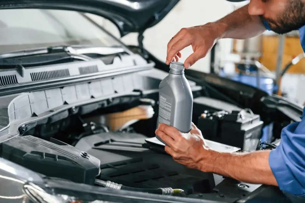 Un homme qui verse du liquide de frein dans la voiture