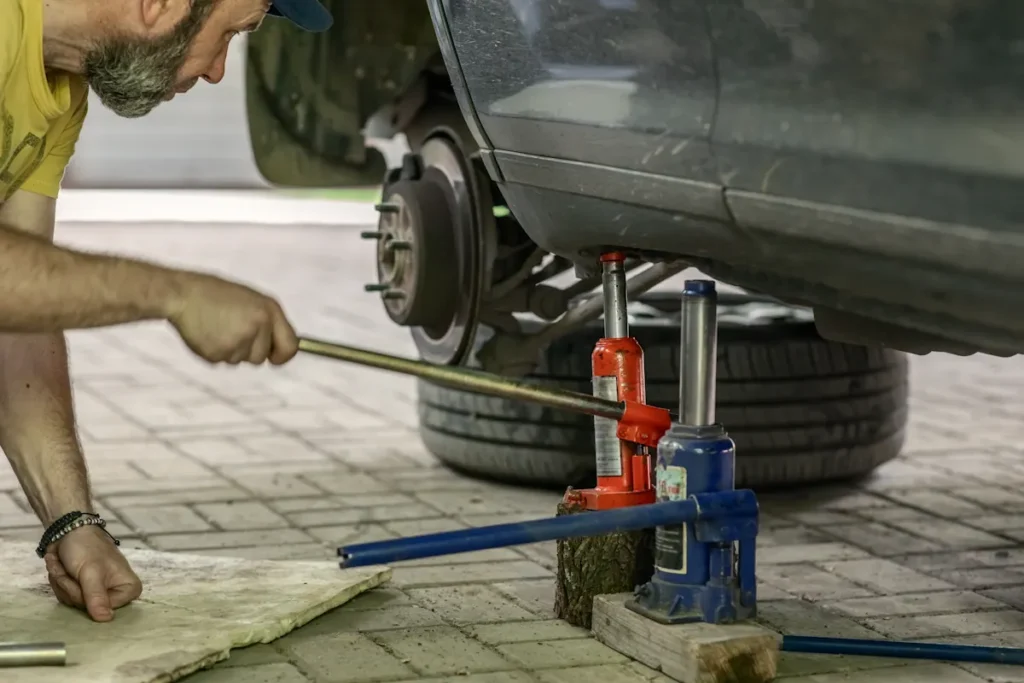 Un homme qui utilise un cric hydraulique