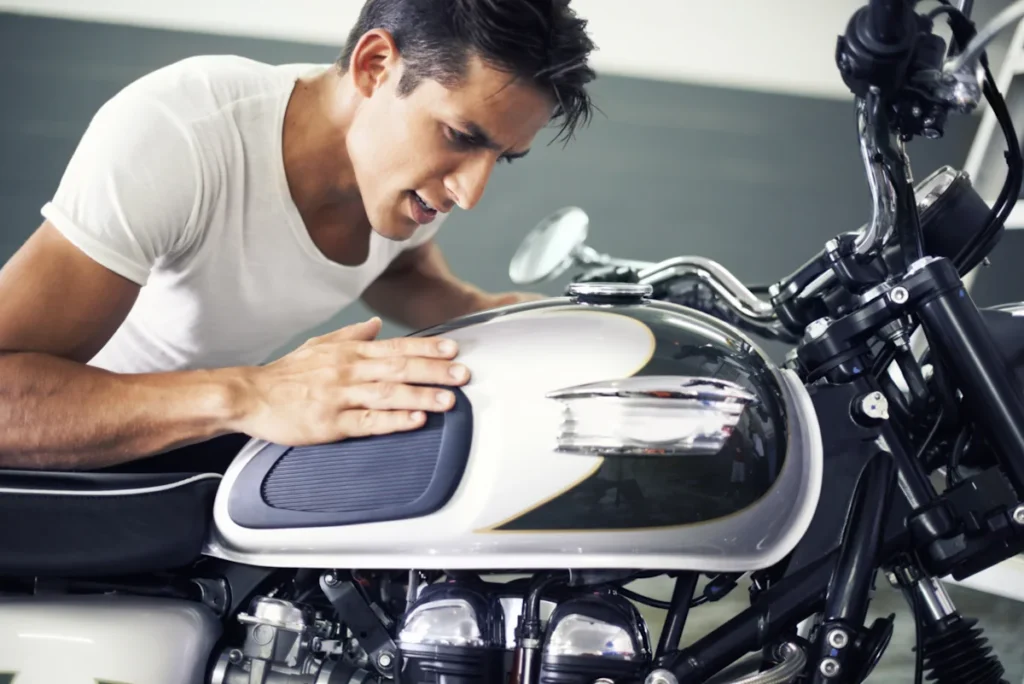 Un homme qui nettoie son réservoir de moto