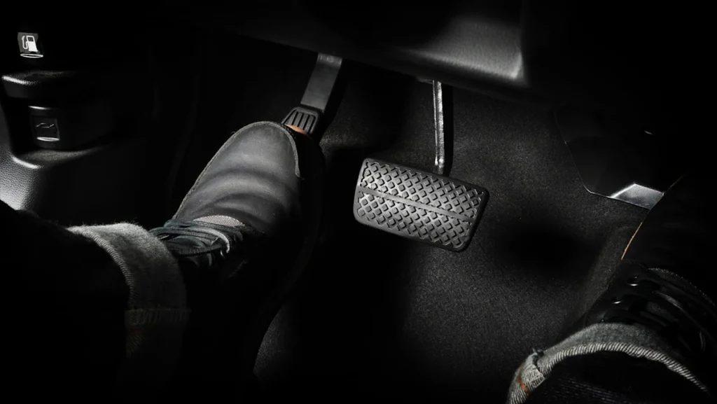 Un homme qui utilise la pédale d'embrayage d'une voiture