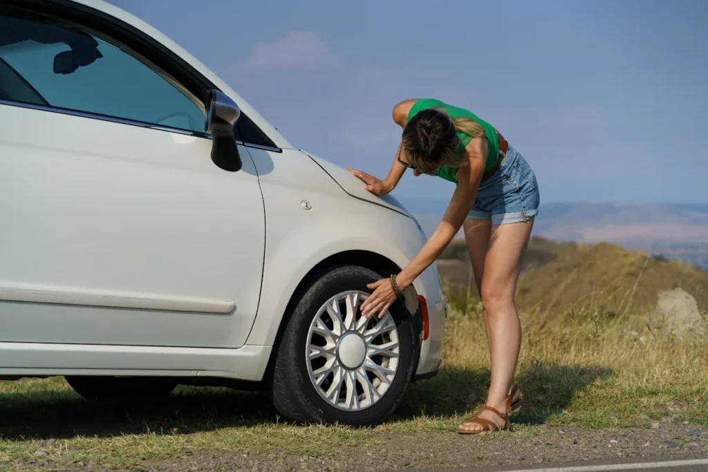 Une femme qui vérifie la pression de son pneu avant