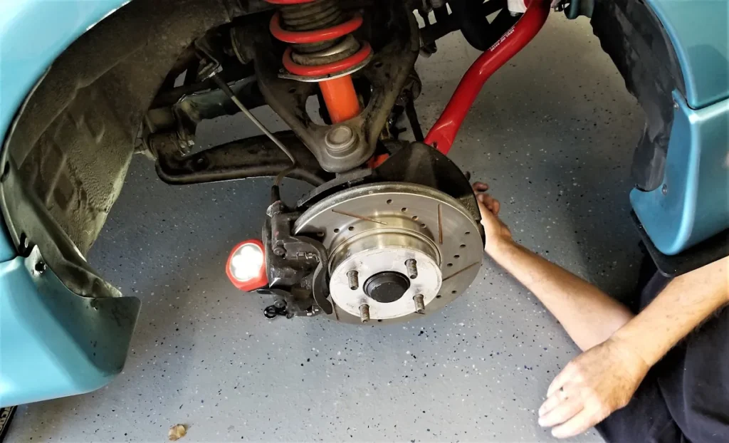 Un homme qui remet le piston dans l'étrier de frein